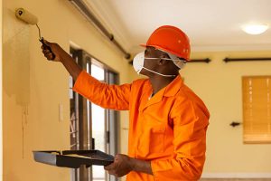 Services professional african construction worker painting the wall